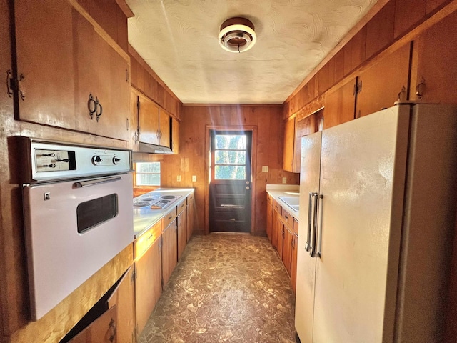 kitchen with white appliances and wooden walls