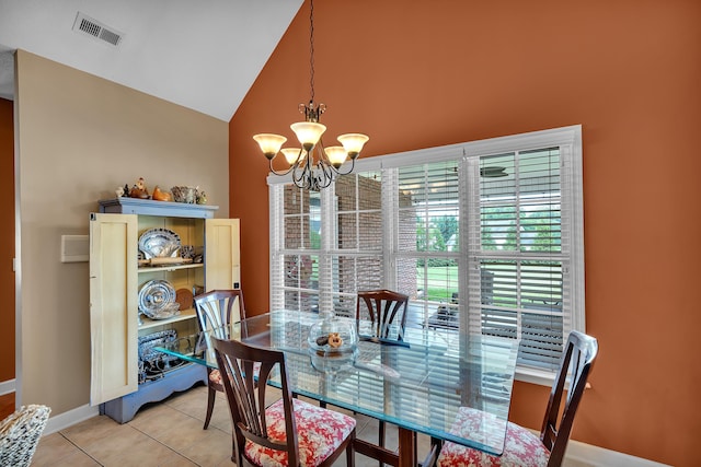 tiled dining space with a chandelier and vaulted ceiling