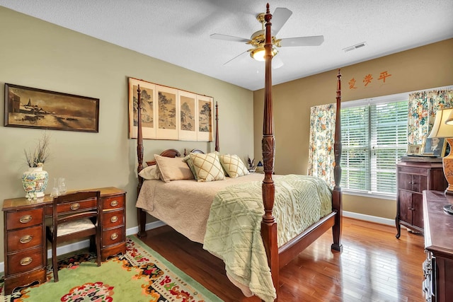 bedroom featuring a textured ceiling, ceiling fan, and hardwood / wood-style floors