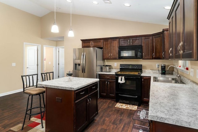 kitchen with dark wood-type flooring, hanging light fixtures, a kitchen island, black appliances, and sink