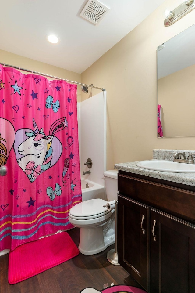 full bathroom featuring shower / bath combo with shower curtain, hardwood / wood-style floors, toilet, and vanity