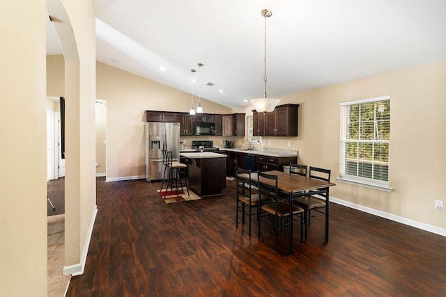 dining area with high vaulted ceiling, dark wood-type flooring, and sink