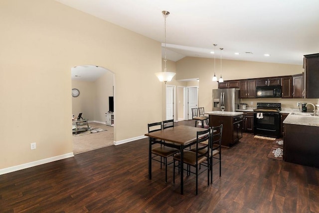 dining room with sink, dark hardwood / wood-style floors, and lofted ceiling