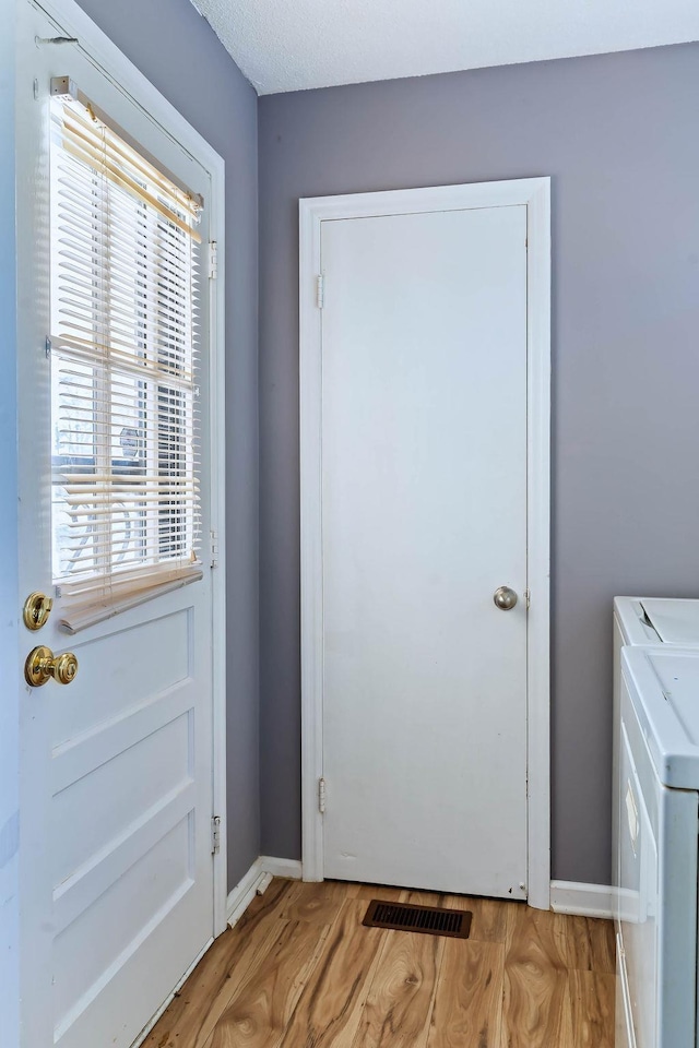 entryway with light hardwood / wood-style floors and washer and clothes dryer