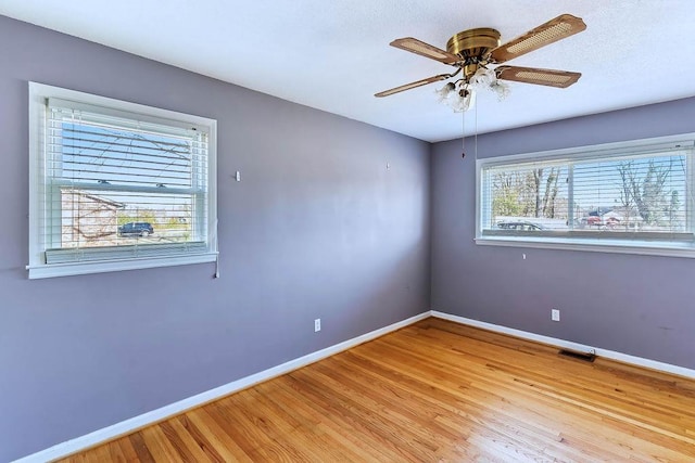 spare room with light wood-type flooring and ceiling fan