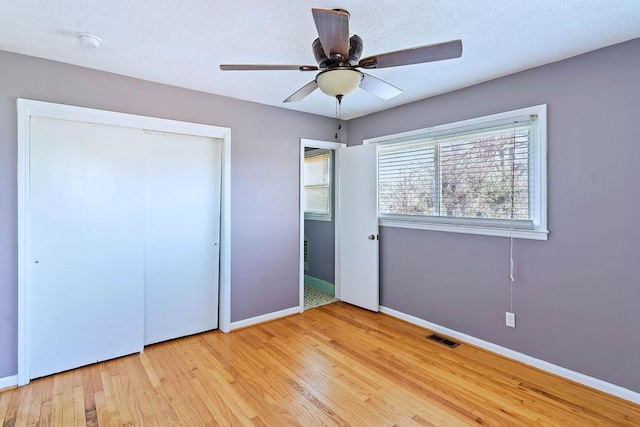 unfurnished bedroom with ceiling fan, a closet, and light hardwood / wood-style flooring