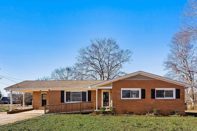 ranch-style home featuring covered porch, a front yard, and a carport