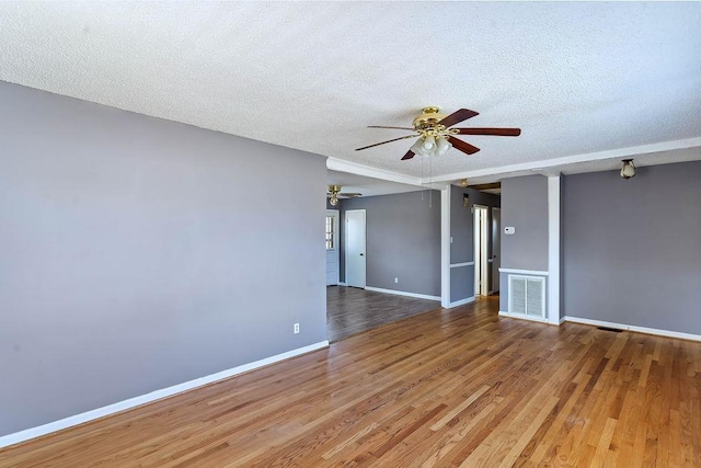 empty room featuring hardwood / wood-style flooring, a textured ceiling, and ceiling fan