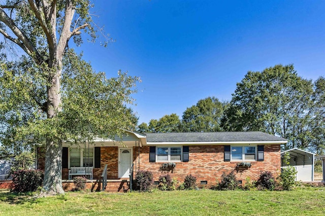 ranch-style home featuring a front yard, a porch, and a carport