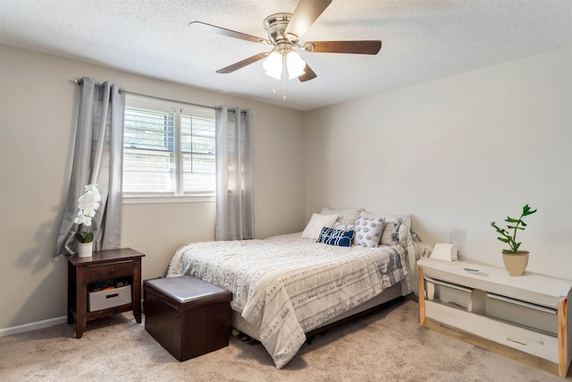 bedroom featuring ceiling fan, a textured ceiling, and light carpet