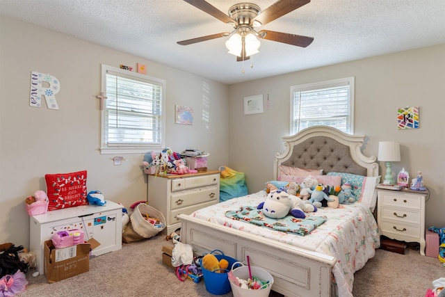 carpeted bedroom featuring ceiling fan, multiple windows, and a textured ceiling