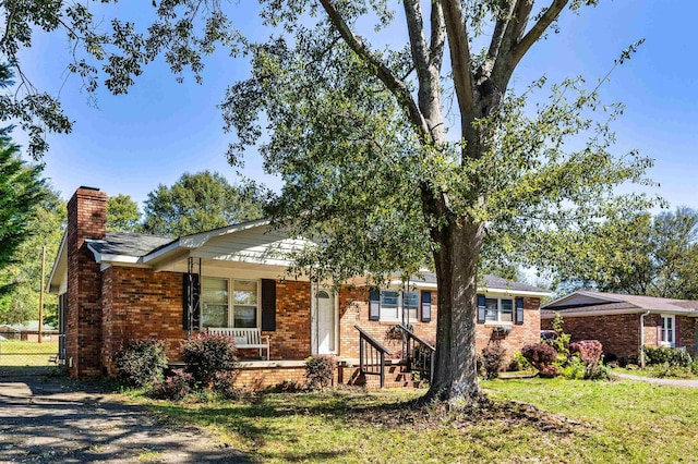 ranch-style house with covered porch and a front lawn