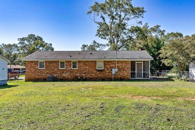 rear view of property featuring central AC, a yard, and a sunroom