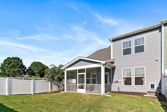 back of house with a sunroom and a lawn