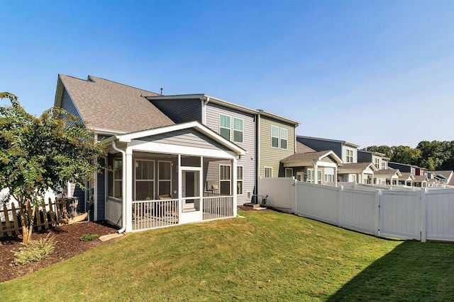 back of property with a sunroom and a yard