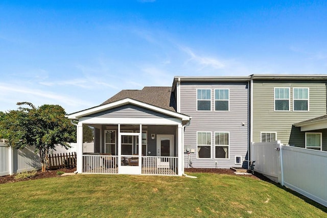 back of property featuring a sunroom and a yard