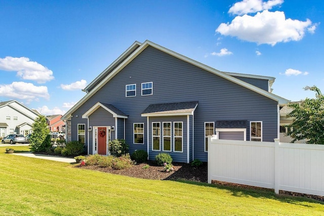 back of property featuring a garage and a yard