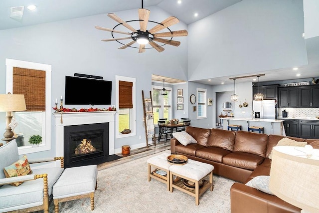 living room featuring high vaulted ceiling and ceiling fan