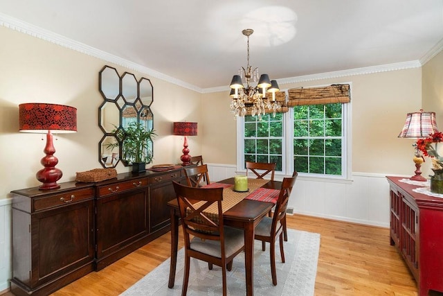 dining space featuring light hardwood / wood-style floors, crown molding, and a notable chandelier