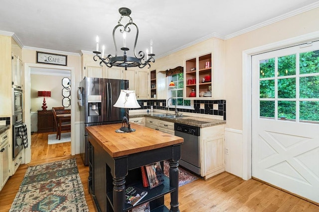 kitchen with pendant lighting, wooden counters, stainless steel appliances, an inviting chandelier, and sink