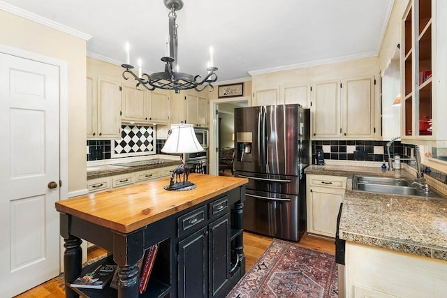 kitchen with appliances with stainless steel finishes, decorative backsplash, a chandelier, and sink