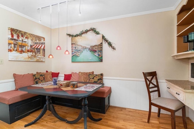 dining space featuring crown molding, light hardwood / wood-style flooring, breakfast area, and rail lighting