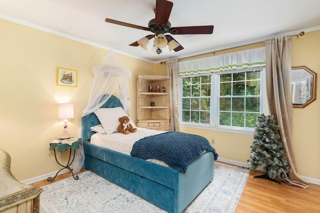 bedroom featuring ceiling fan, crown molding, and hardwood / wood-style flooring