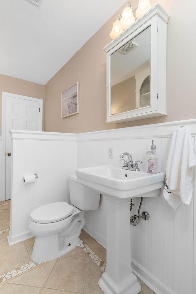 bathroom featuring toilet, tile patterned flooring, and wood walls