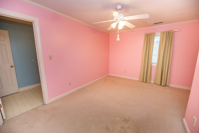 spare room featuring ornamental molding, light carpet, and ceiling fan