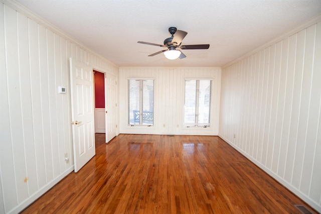 spare room featuring ceiling fan, ornamental molding, hardwood / wood-style floors, and a textured ceiling