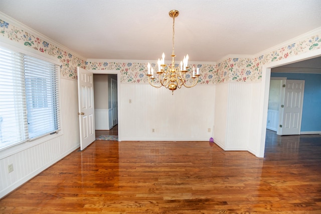 unfurnished dining area featuring ornamental molding, a chandelier, and dark hardwood / wood-style flooring