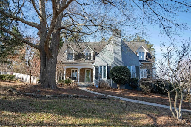 cape cod-style house with covered porch