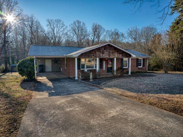 ranch-style home with a porch and a carport