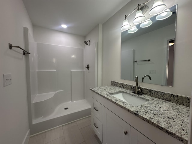 bathroom with vanity, a shower, and tile patterned floors