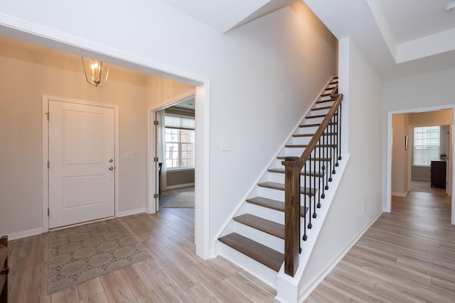 entrance foyer featuring light hardwood / wood-style floors and a notable chandelier