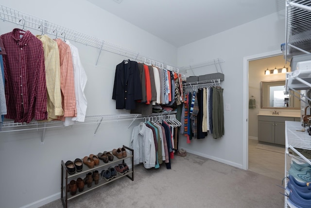 walk in closet featuring light carpet and sink