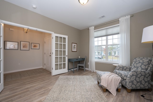 living area with light hardwood / wood-style flooring and french doors