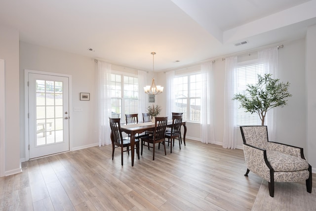 dining room with plenty of natural light, a chandelier, and light hardwood / wood-style floors