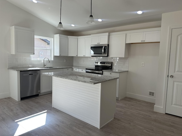 kitchen featuring white cabinetry, appliances with stainless steel finishes, lofted ceiling, pendant lighting, and a center island