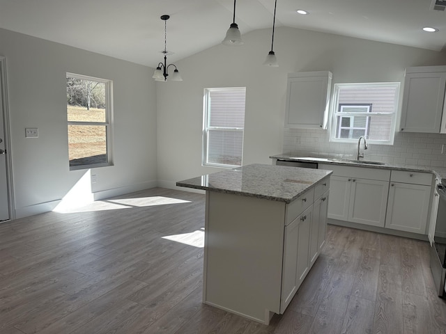 kitchen with white cabinets, a center island, sink, and pendant lighting