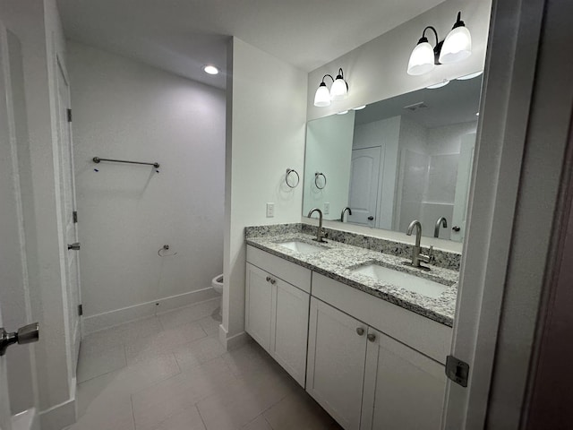 bathroom featuring toilet, vanity, and tile patterned flooring