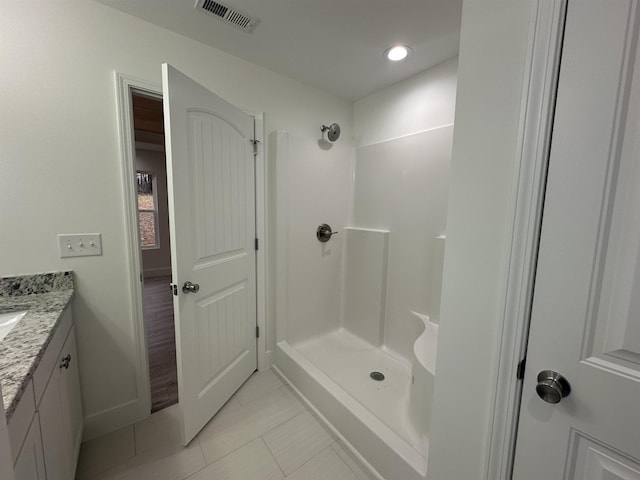 bathroom with a shower, vanity, and tile patterned flooring