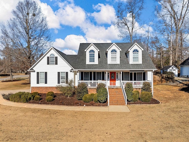 cape cod house featuring a front lawn and a porch