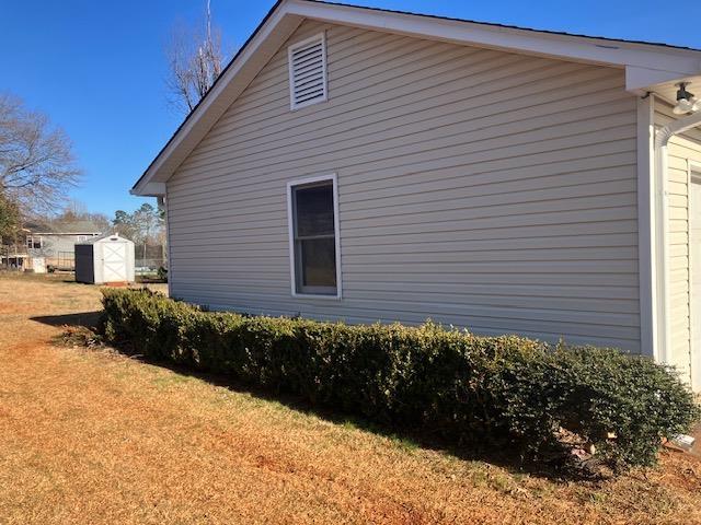 view of home's exterior featuring a yard and a storage shed