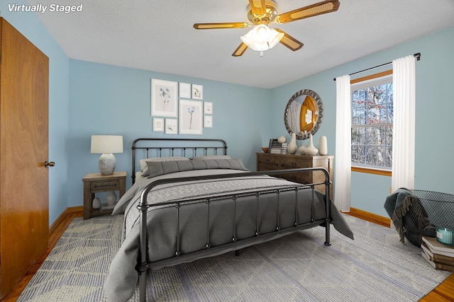 bedroom featuring ceiling fan, wood-type flooring, and a textured ceiling