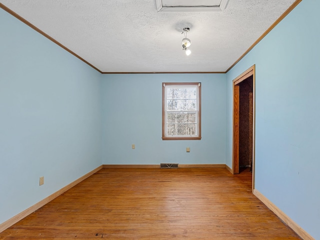 spare room with a textured ceiling, crown molding, and light hardwood / wood-style flooring