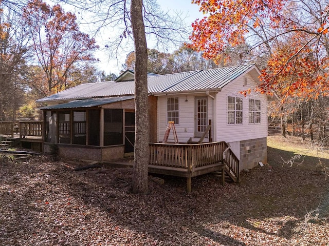 back of property featuring a wooden deck and a sunroom