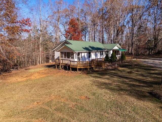 view of front facade with a front yard and a wooden deck