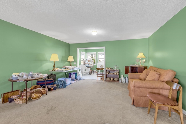 recreation room with a textured ceiling and light carpet