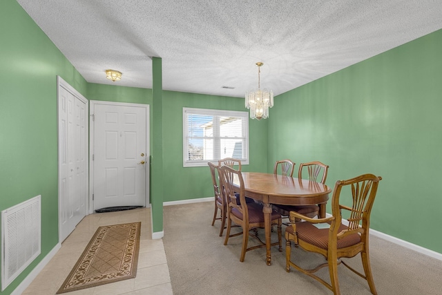 tiled dining room with a chandelier